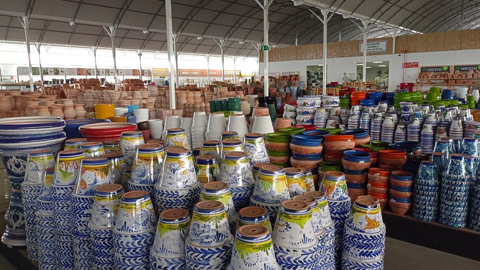 Rows of colorful ceramic pots inside a large garden supply store.